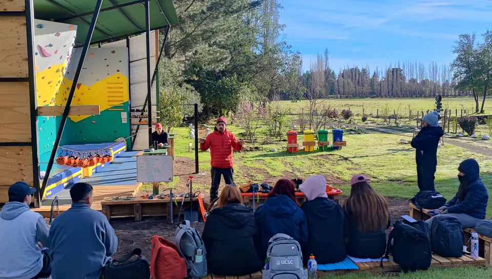 Grupo de estudiantes escuchando una actividad al aire libre